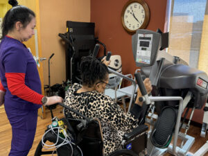 One of Coffman Nursing Home's therapists works with a resident on improving her leg strength.